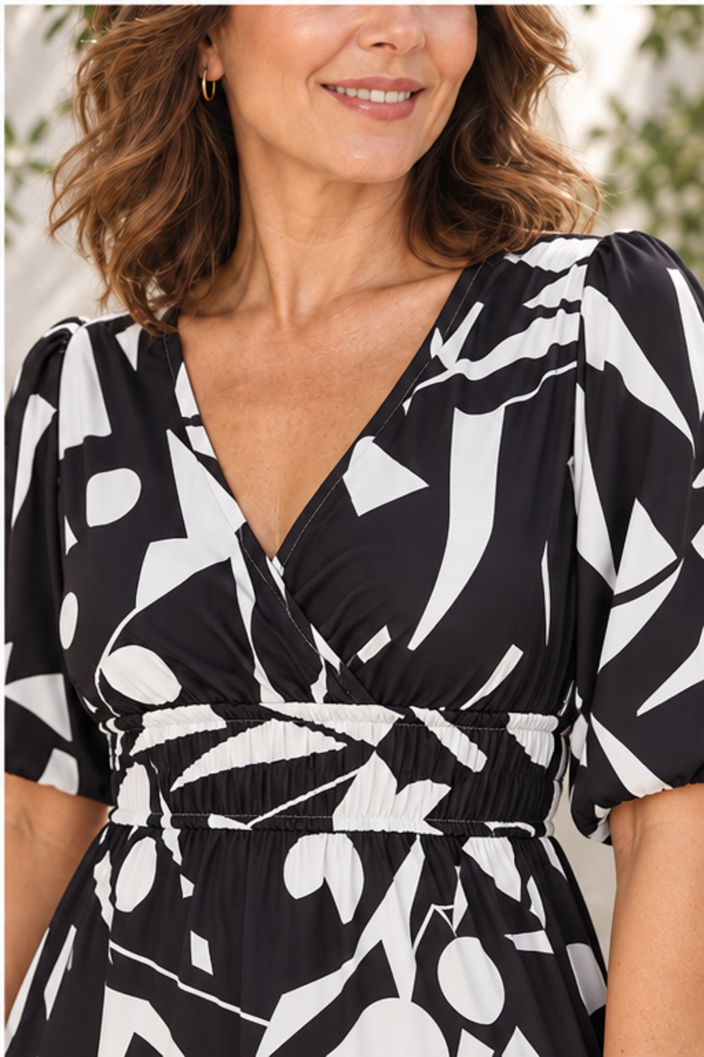 Printed surplice balloon sleeve dress in black, close-up of print, neckline, sleeves and smocked waist