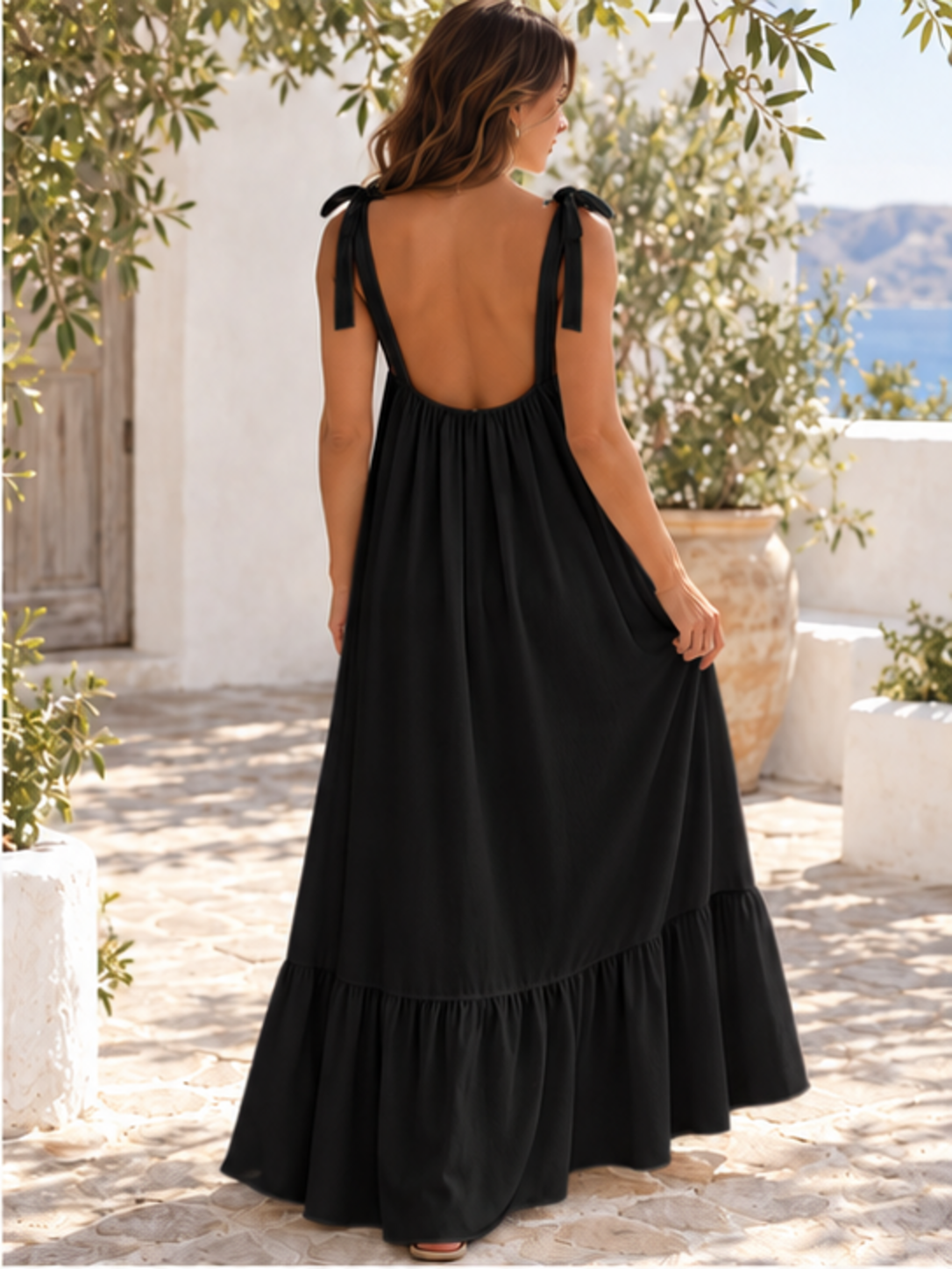 Sleeveless tie-strap flowy maxi dress in black, back full-length view showing the tied shoulder straps
